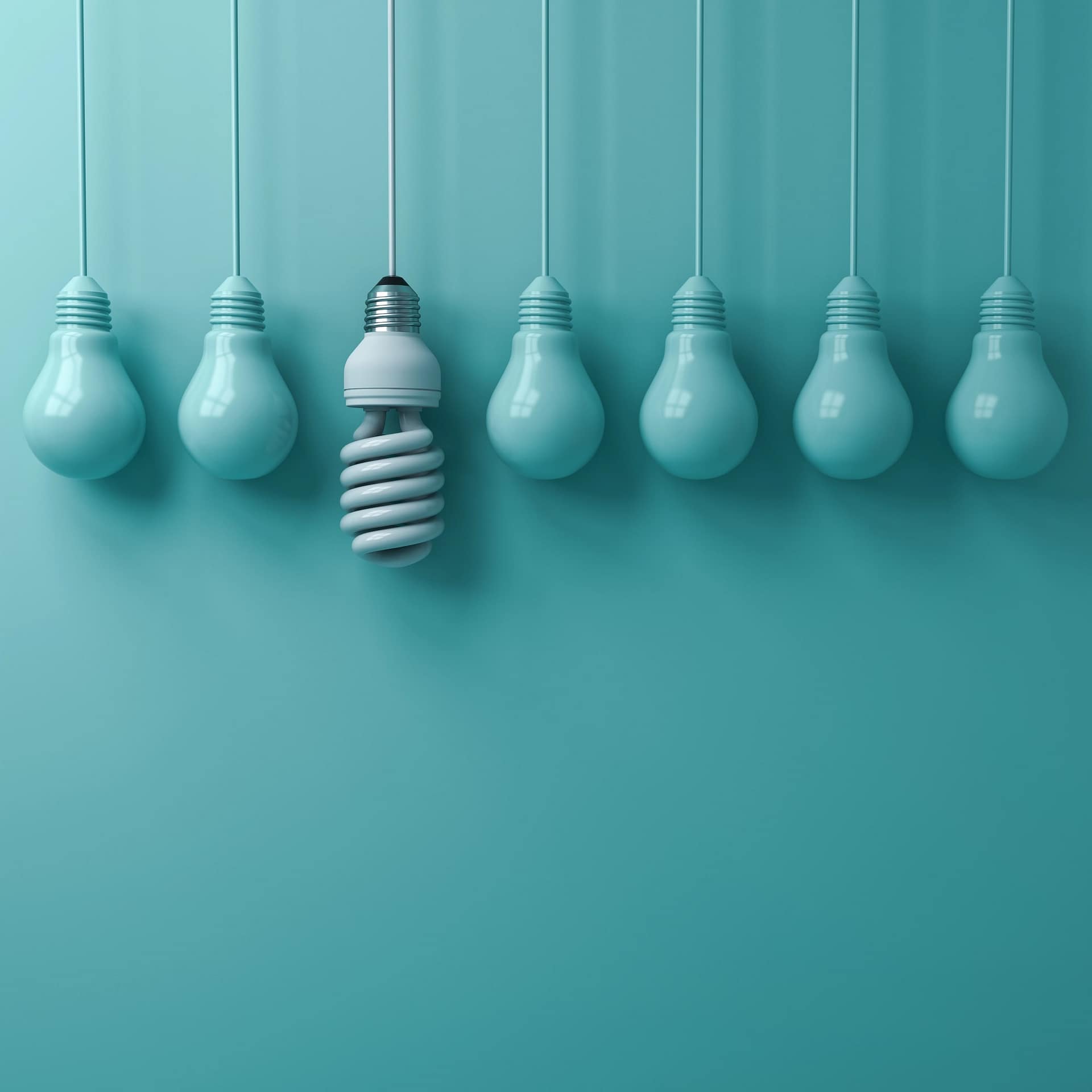 Siete bombillas cuelgan sobre un fondo turquesa; una de ellas, con su diseño en espiral de bajo consumo, evoca el espíritu de Séneca y la virtuosa simplicidad estoica, en contraste con las seis bombillas tradicionales.